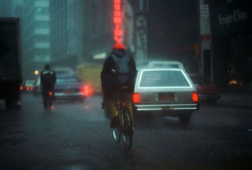 ca. March 1983, New York, New York, USA --- Riding a Bicycle in the Rain --- Image by © Vince Streano/CORBIS